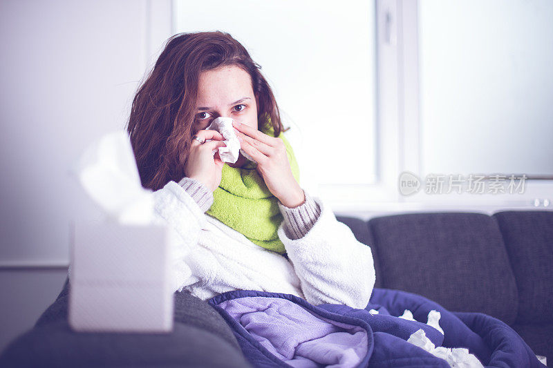 生病的女人患流感头痛在床上