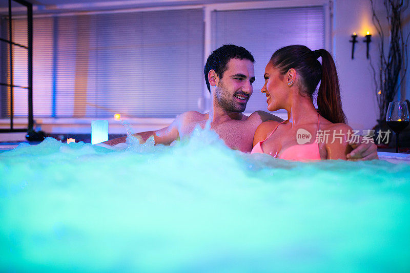 一对深情的夫妇在健康水疗中心的热水浴缸中放松