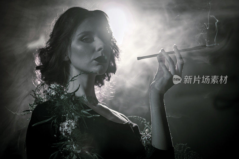 年轻女子的肖像在花围巾与香烟