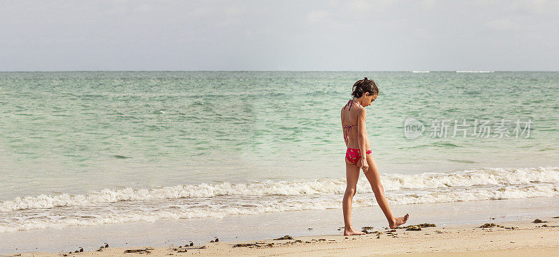 独自在海滩上行走的小女孩
