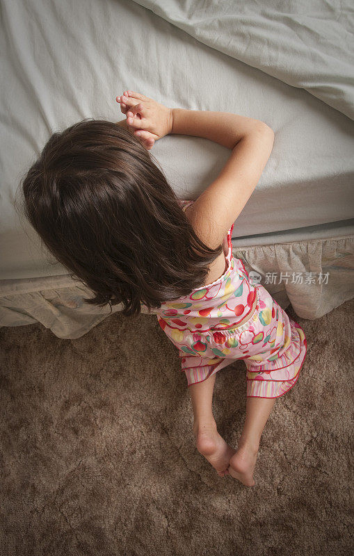 小女孩在床边祈祷
