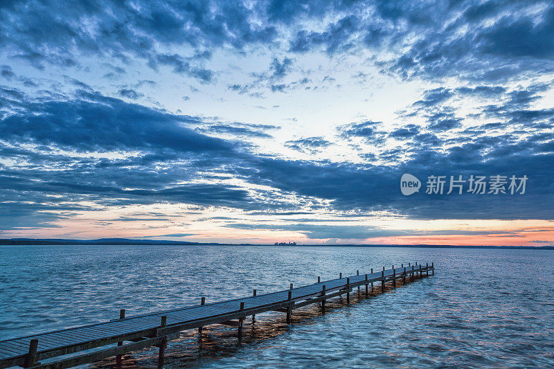 湖泊和码头与雄伟的云彩景观在黄昏