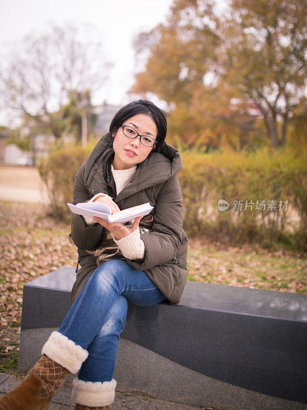 女人看书，看着相机