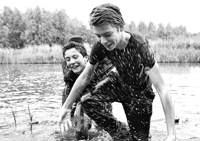 男孩在泥跑活动中跨越水障碍