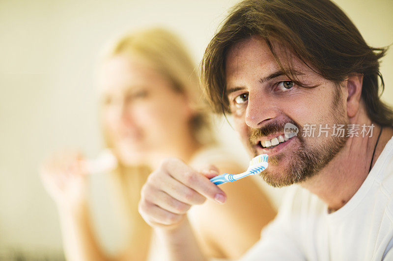 一对夫妇在早上刷牙。