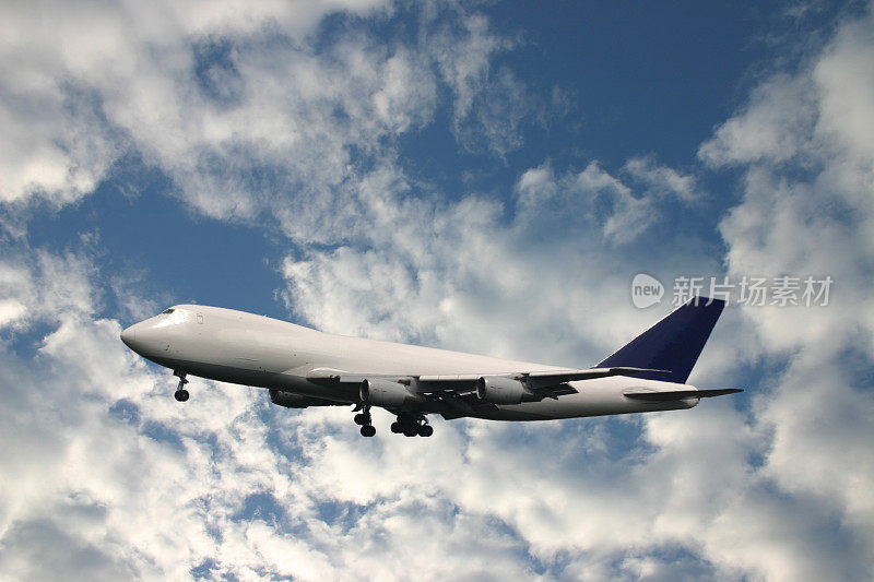一架货机在蔚蓝多云的天空前