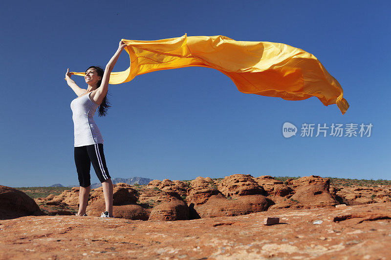 年轻的女跑步者，织物在风中飞舞