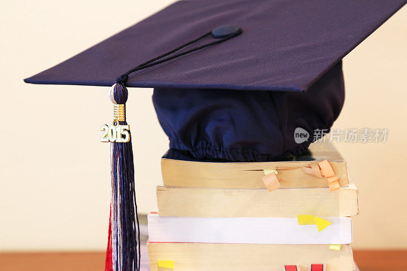 一堆书上的毕业帽