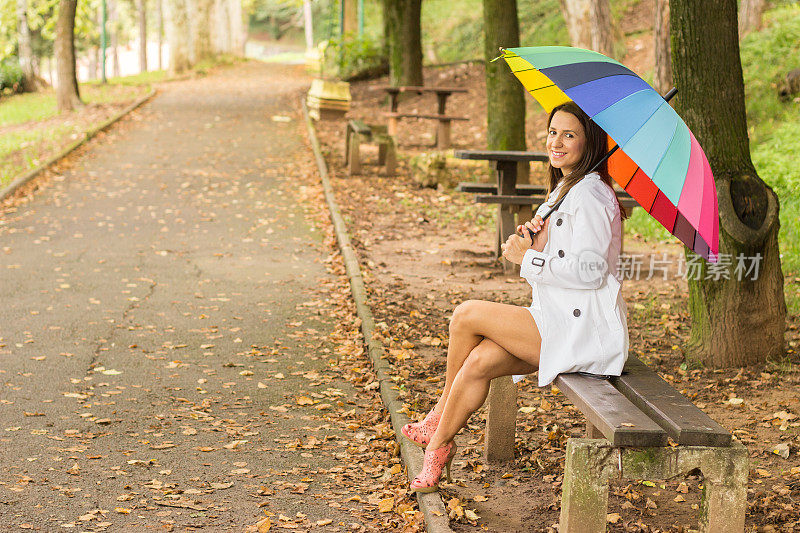 黑发女孩在森林里拿着五颜六色的雨伞