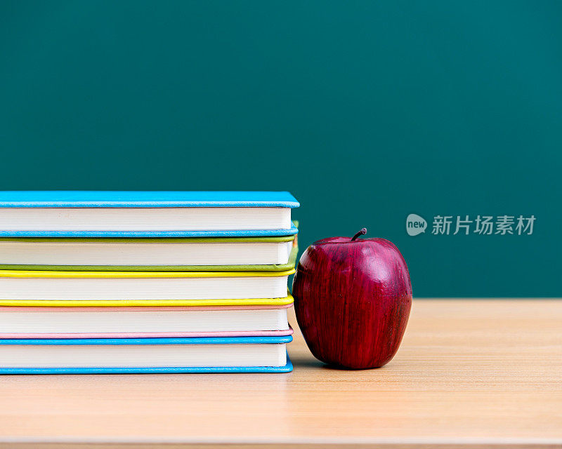 黑板旁边放着苹果和书