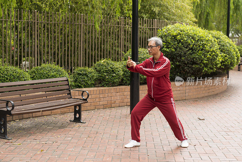 成熟的中国男子在公园里练习太极拳