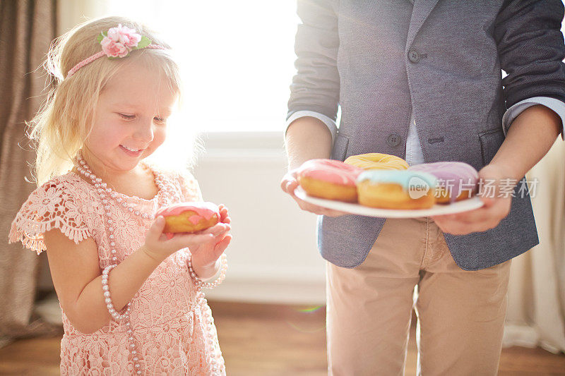 快乐的小女孩和她哥哥送的甜甜圈