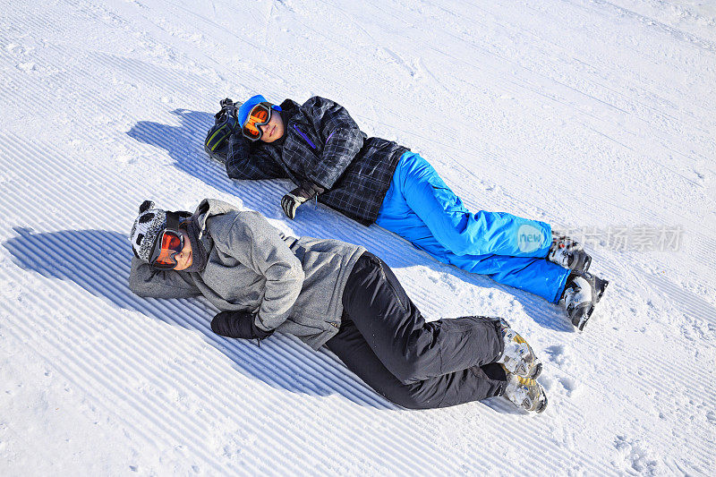 青少年男孩和女孩滑雪享受日光浴