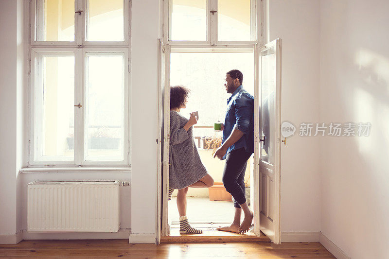 一对美国黑人夫妇站在家里的窗边