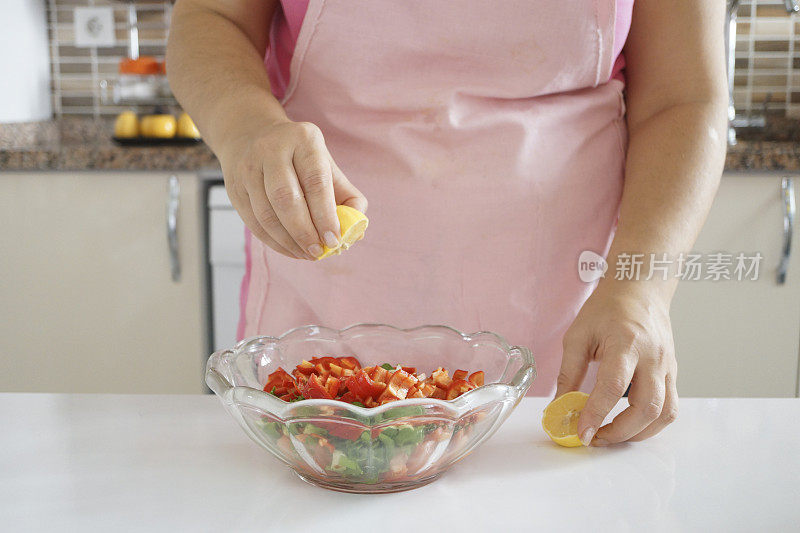 女人在厨房里做健康的食物，蔬菜沙拉