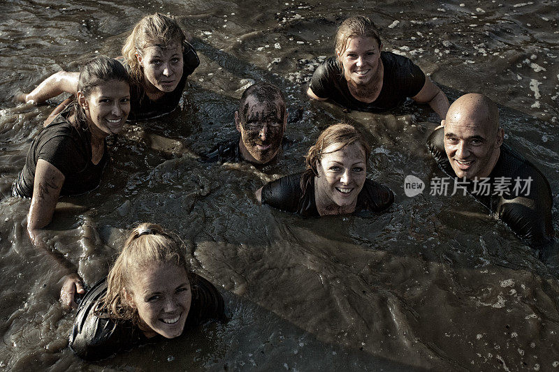 一群快乐的朋友在泥泞的运河里游泳