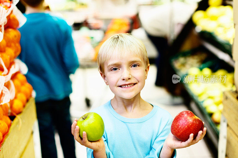 快乐的小女孩在超市挑选苹果
