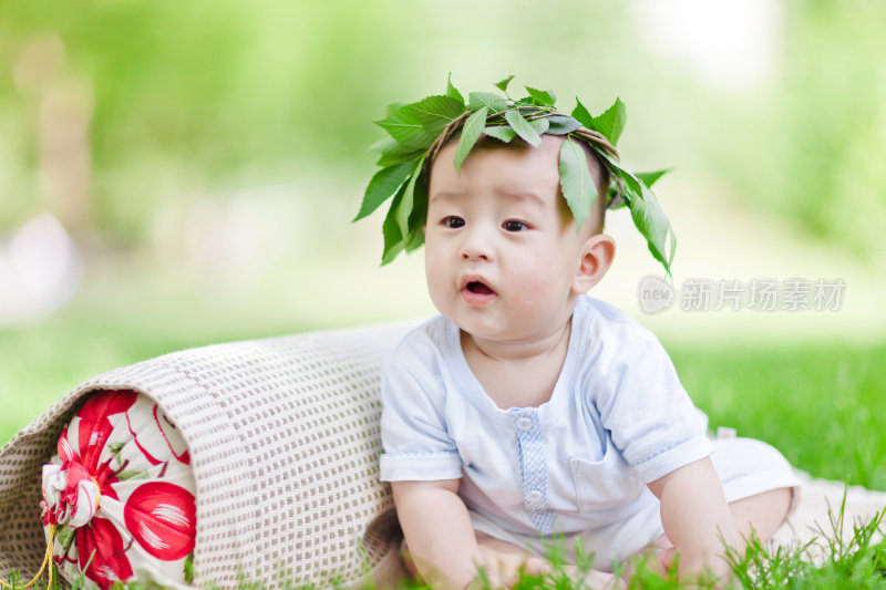 可爱的亚洲小男孩坐在草坪上