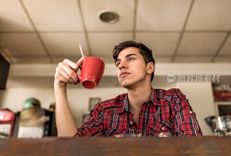 下面是一个沉思的年轻人在咖啡馆。