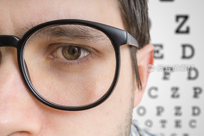 戴眼镜的人正在检查视力。眼睛的近景。