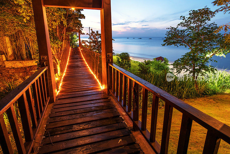 日落时分热带岛屿上的木制人行桥