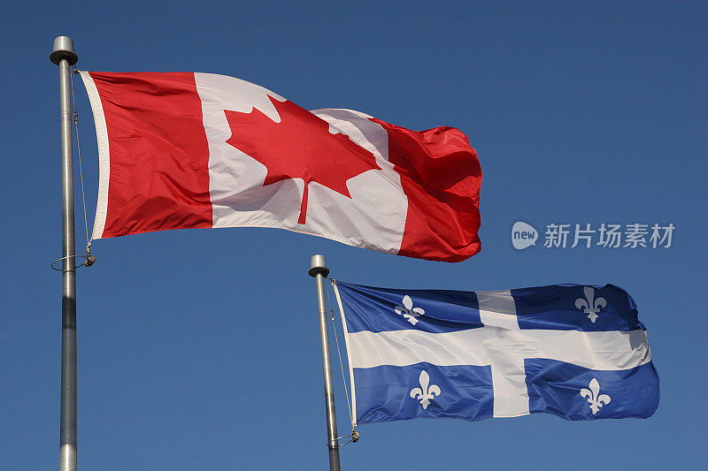 加拿大和魁北克省的国旗在蓝天上飘扬