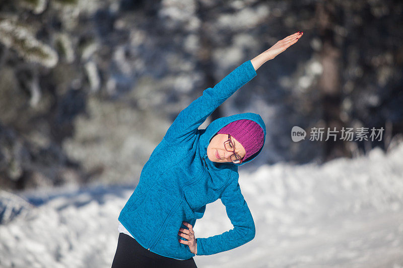 活跃的女士在雪道上热身