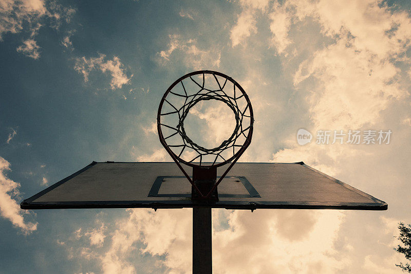 蓝蓝的多云天空背景下的篮球篮板