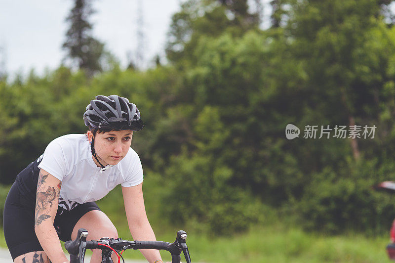 一名骑自行车的女性沿着乡村公路骑行