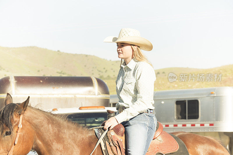 在犹他州山上骑着马的女牛仔