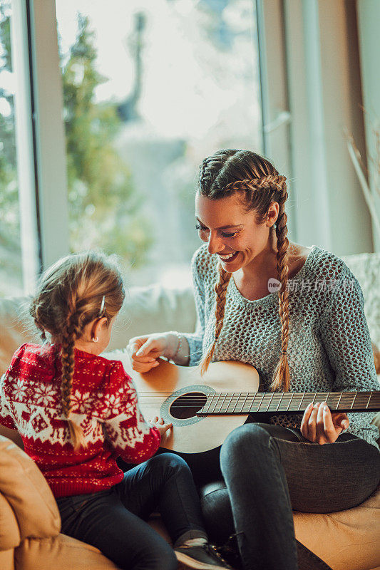 妈妈和小女孩一起唱歌，弹吉他