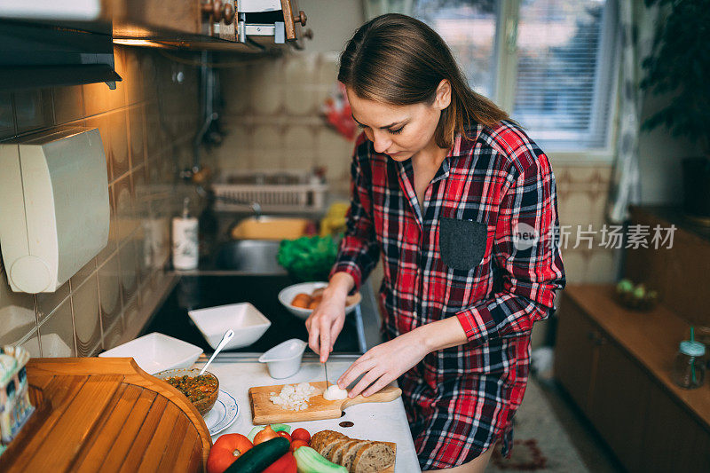 穿着随意的女人在厨房里准备健康的饭菜