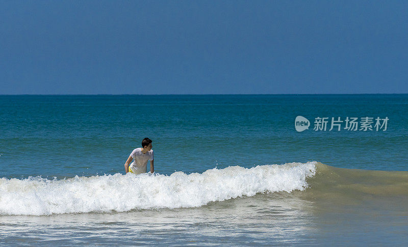 在帕卡朗海滩上冲浪的年轻人