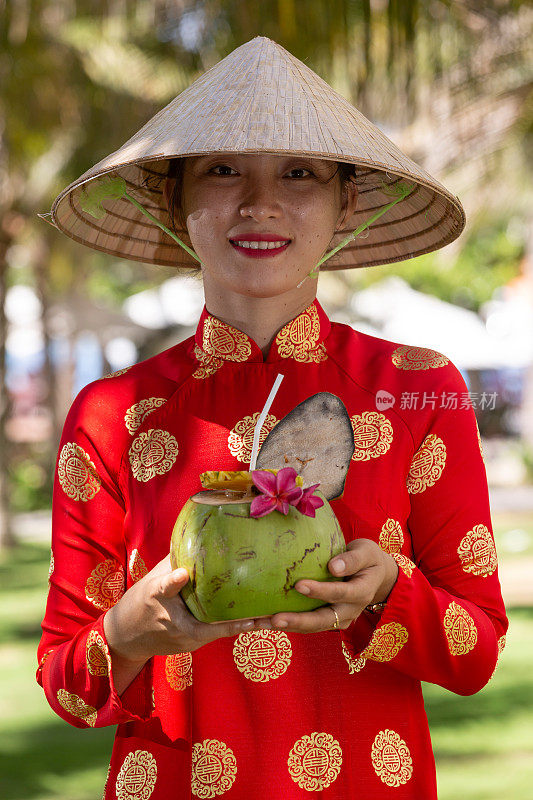 异国情调的传统越南女孩，同时提供新鲜的椰果和鲜花