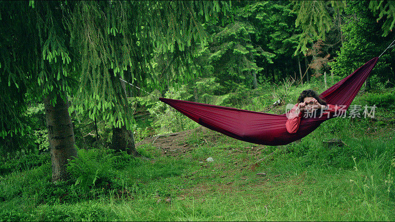 在吊床上休息的女人。野营