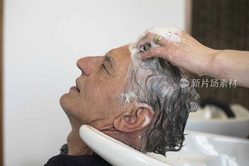 美发师在老人的头发上涂洗发水