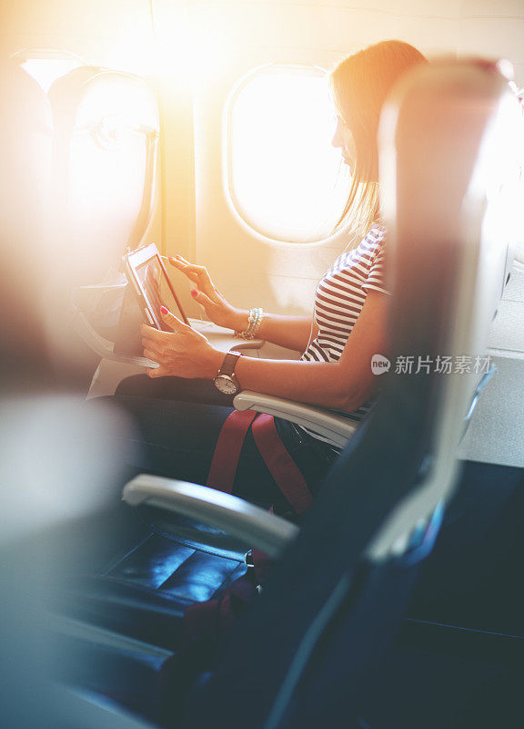飞机女乘客在飞行中使用平板电脑