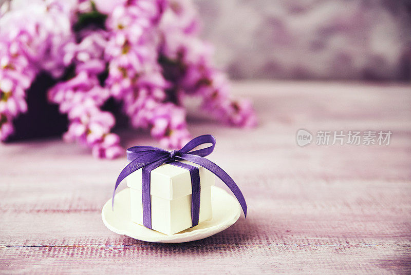 紫丝带和紫藤花束的礼盒
