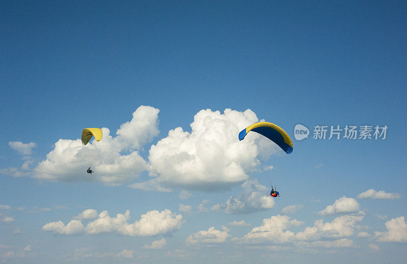 滑翔伞在蓝天中飞翔。两架滑翔伞在白云的背景下在蓝天上飞行。