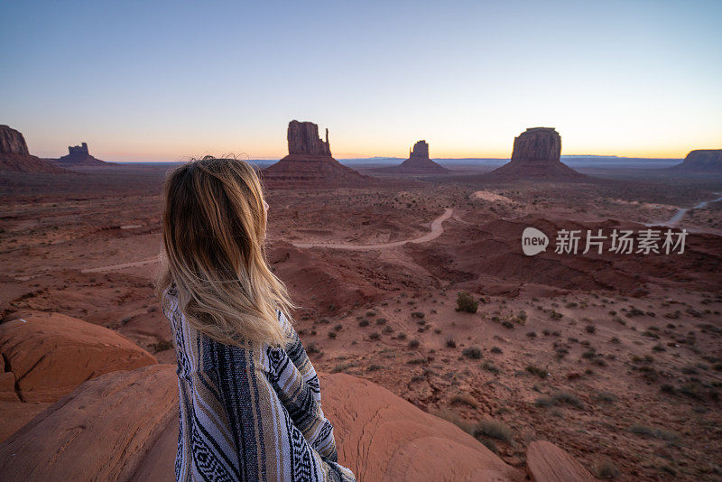 女孩在美国纪念碑谷的岩石上欣赏日出