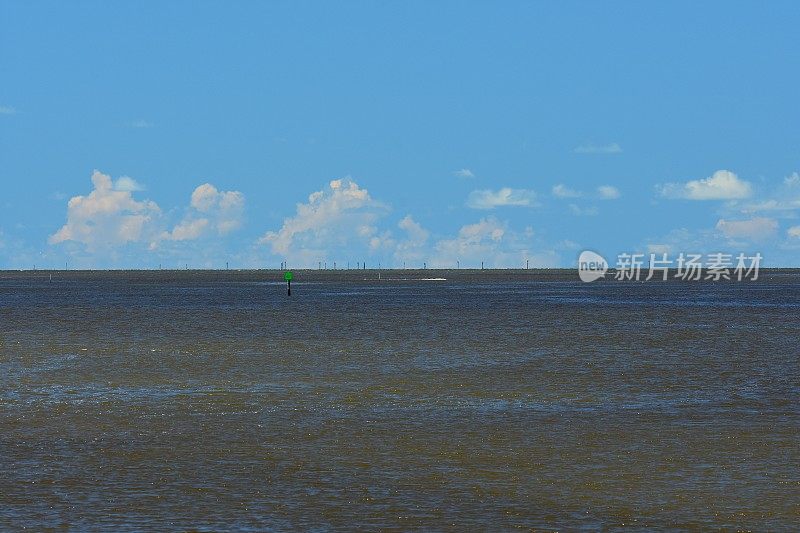沿海水域的夏季云带着导航设备和标记沙洲的杆子