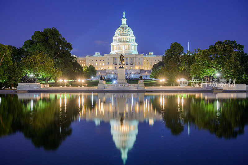 美国华盛顿特区的国会大厦夜景，在池塘中倒影