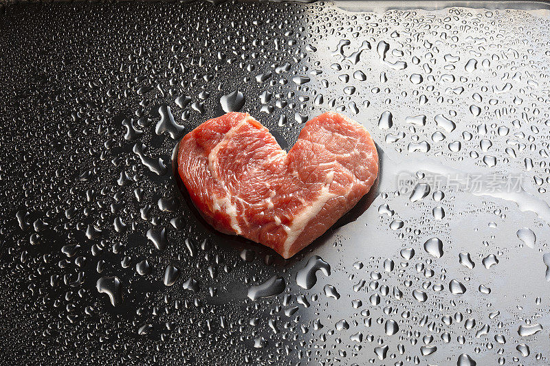 在不锈钢容器中加入一滴培养基的心形人造牛肉。