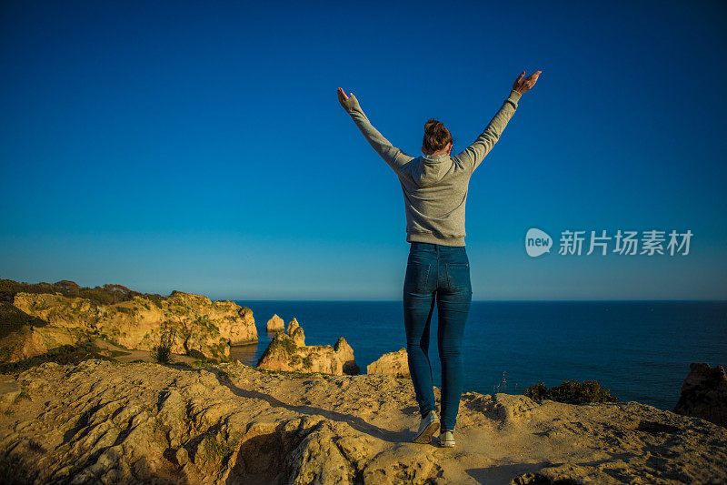 年轻的黑发女性享受她的自由在阿尔沃葡萄牙在夏末的阳光海滨