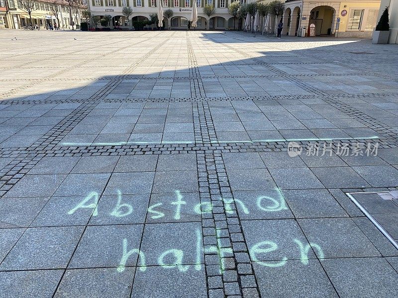 市场广场上的保持距离文字，德语:保持距离
