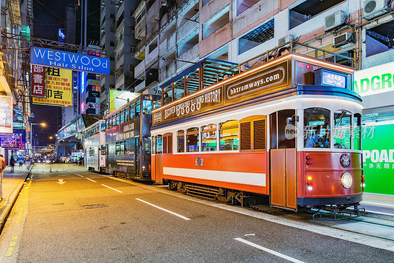 传统的观光电车在夜晚的城市街道上。