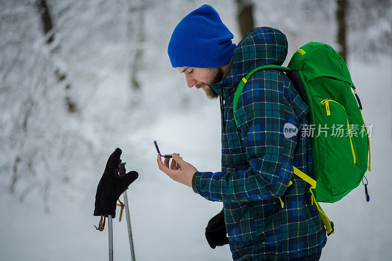 这个人看着雪山背景上的指南针