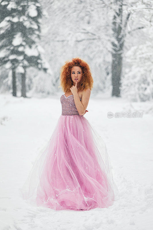 我的冬日童话，美丽的女孩穿着华丽的粉红色裙子享受着白雪覆盖的森林