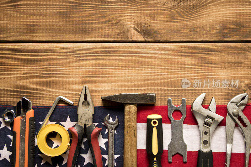劳动节。美国国旗和各种工具的木制背景。劳动节的概念。文本的空白。