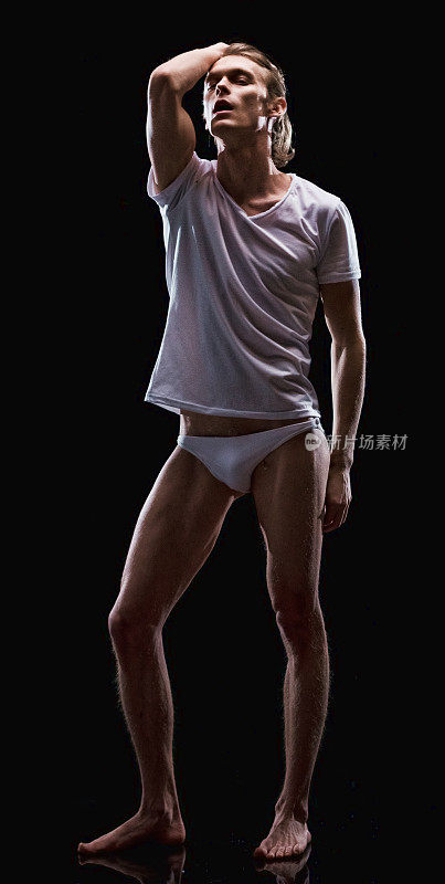 白人男性脱衣舞娘前面的黑色背景穿着t恤